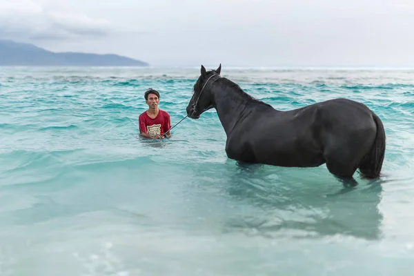 Mann mit Pferd im Meer — Stockfoto