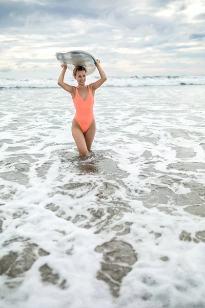 Vrouw met surfboard op strand — Stockfoto