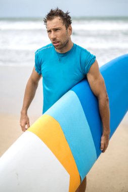 Adam sahilde surfboard ile