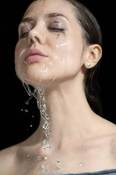 Wasser spritzt auf das Gesicht der Frau — Stockfoto