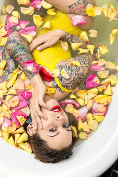 Tätowiertes Mädchen posiert in Badewanne — Stockfoto