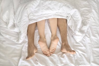 Battaniyenin altındaki aşıkların bacakları