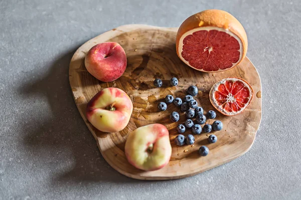 Fruta fresca y jugosa sobre tabla de madera —  Fotos de Stock