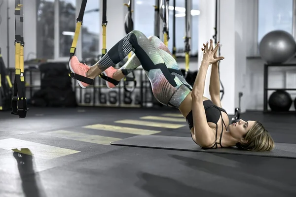 Sportive girl does exercise in gym — Stock Photo, Image