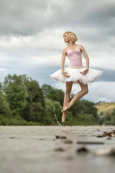 Bailarina saltando por encima del río — Foto de Stock