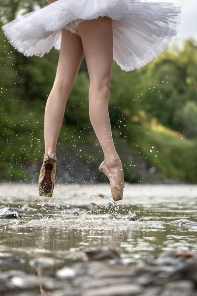 Ballerina jumping in river