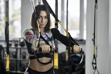 Sportif kız spor salonunda egzersiz yapıyor.