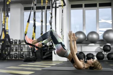 Sportif kız spor salonunda egzersiz yapıyor.