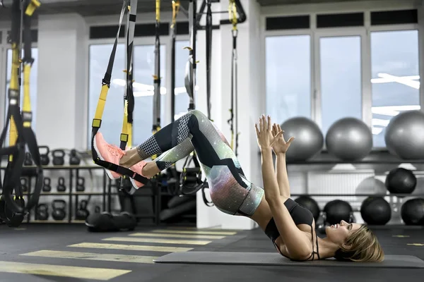 Sportif kız spor salonunda egzersiz yapıyor.