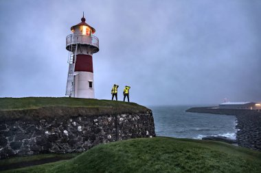 Seashore with luminous lighthouse clipart