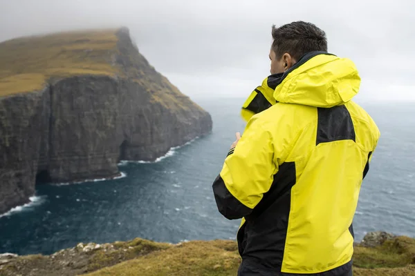 Guy op klif aan kust — Stockfoto