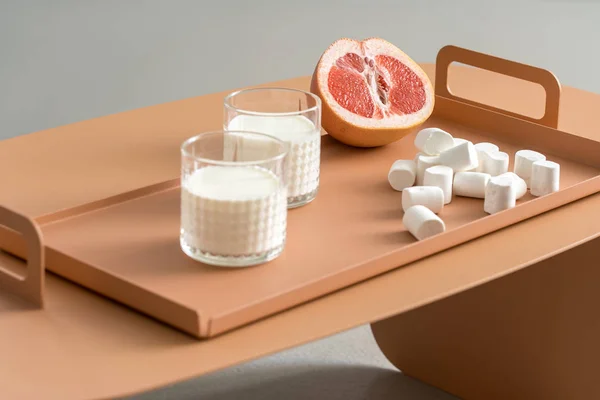 Grapefruit, marshmallows and glasses with milk — Stock Photo, Image