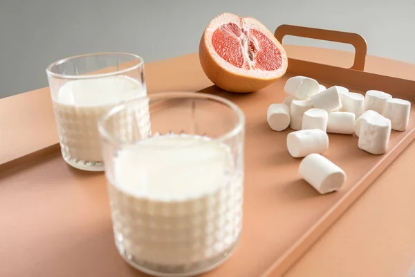 Grapefruit, Marshmallows und Gläser mit Milch — Stockfoto