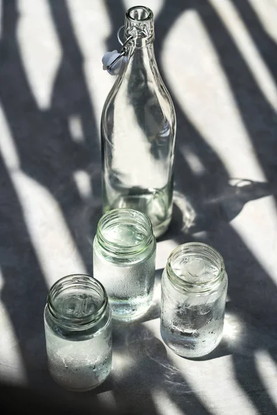 Bottle with glass jars Stock Photo