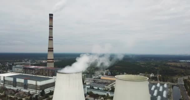 Dampfende Kraftwerke und Verwaltungsgebäude vor dem wolkenverhangenen Himmel. Luftbildaufnahme. — Stockvideo