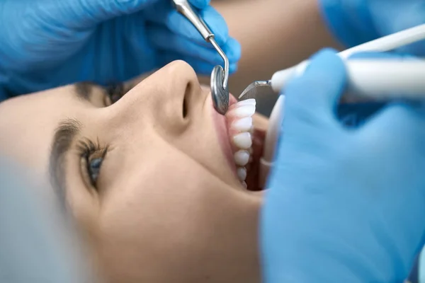 Mooie Womans tanden behandeling in de tandheelkundige kliniek — Stockfoto