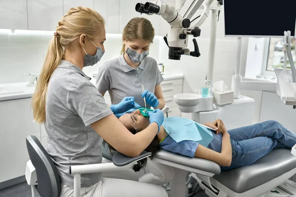 Pretty womans limpieza de dientes en clínica dental —  Fotos de Stock