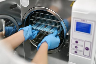 Dişçi sterilizasyon makinesine diş probları yüklüyor