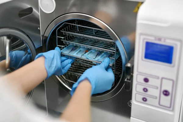 Tandarts laadt tandheelkundige sondes in steriliseren machine — Stockfoto