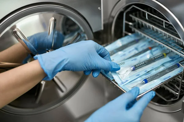 Arzt entnimmt Zahnsonde aus Sterilisierungsmaschine — Stockfoto