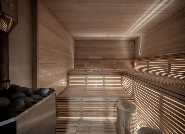 Illuminated wooden sauna with benches and logs