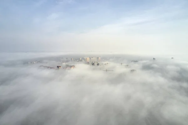 Widok z powietrza na szczyty wieżowców tonących we mgle — Zdjęcie stockowe