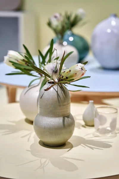Wielokolorowe okrągłe stoły z wazonami z kwiatami — Zdjęcie stockowe
