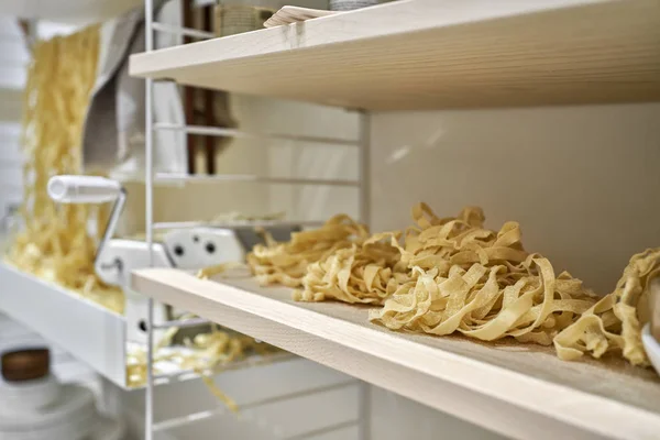 Veel rauwe noedels met pasta maker machine binnen — Stockfoto