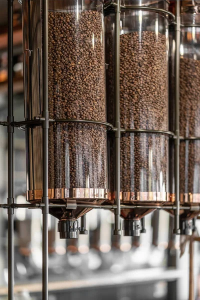 Geroosterde bruine koffiebonen in glazen dispensers — Stockfoto