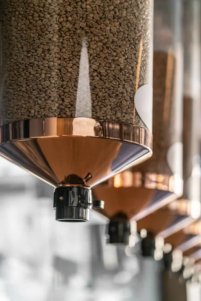 Roasted brown coffee beans inside glass dispensers