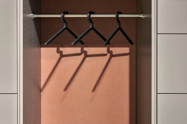 Closeup view at hangers on rack in wardrobe — Stock Photo, Image