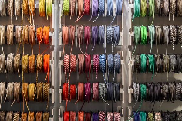 Stand with coils of multicolored textile braided cables — Stock Photo, Image