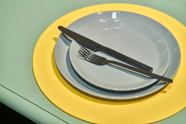 Closeup view at multicolored plates with cutlery — Stock Photo, Image