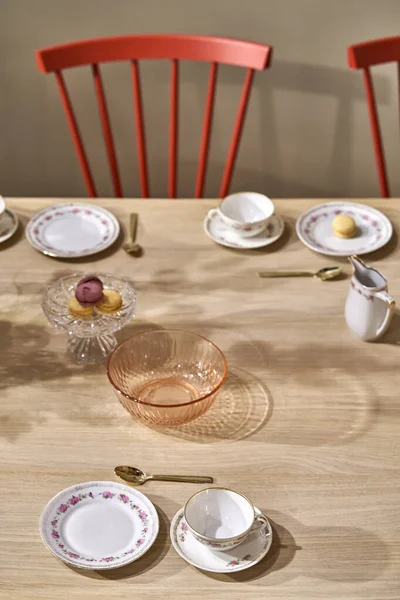 Interior iluminado com mesa servida com cadeiras coloridas — Fotografia de Stock