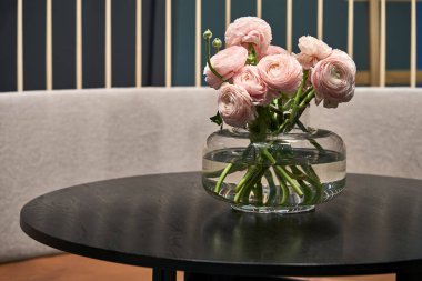 Mobilya ve renkli çiçeklerle aydınlık bir oda.