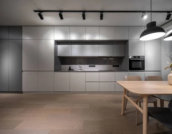 寄木細工の床付きの照明付きモダンなキッチンのインテリア — ストック写真