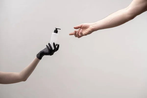 Mão com dispensador de transferências de esterilizador para outra mão feminina — Fotografia de Stock