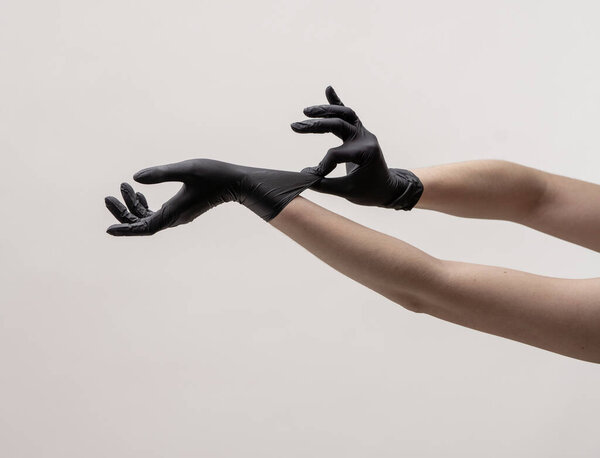 Руки в черных силиконовых перчатках на светлом фоне
.