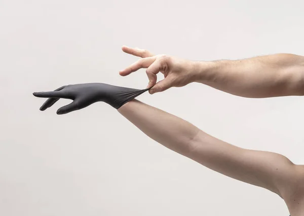 Vrouwelijke hand in een zwarte siliconen handschoen — Stockfoto