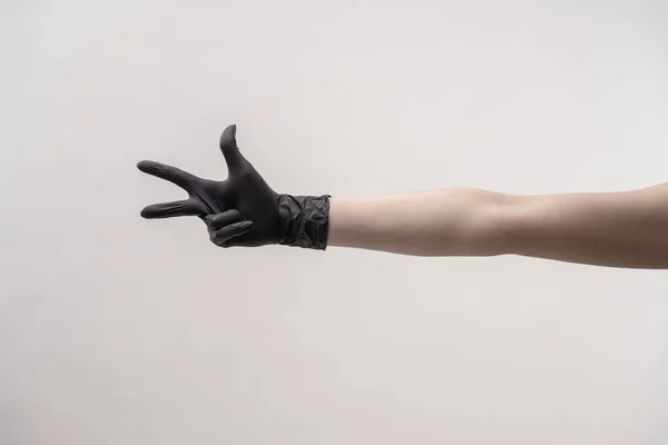 Ruce v černé silikonové rukavice na světlém pozadí. — Stock fotografie