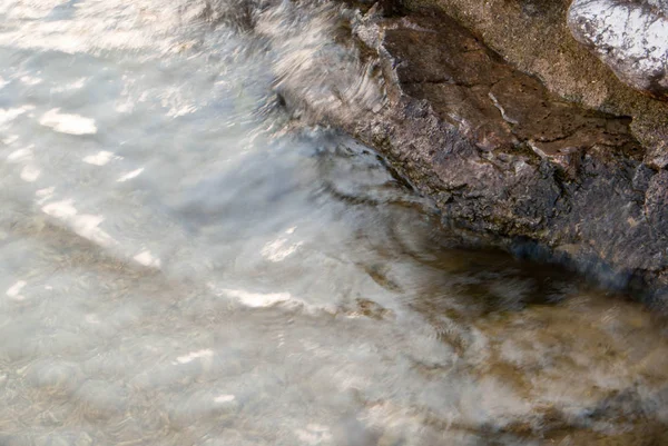 Taş sahilde küçük dalgalar