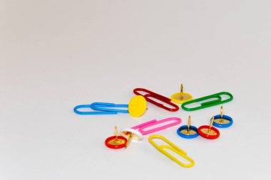 Renkli ataç ve beyaz arka plan üzerinde toplu iğneler