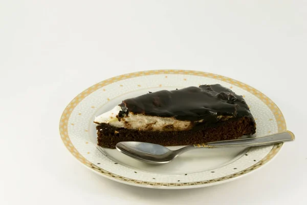 Шоколадный кусок торта на тарелке на белом фоне — стоковое фото