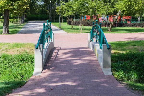 Paesaggio romantico di un ponte pedonale Tourkise in un parco verde — Foto Stock