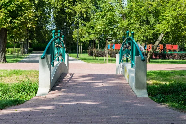 Paesaggio romantico di un ponte pedonale Tourkise in un parco verde — Foto Stock
