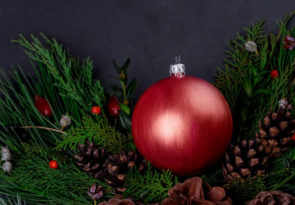 New Year's ball in spruce branches with cones — Stock Photo, Image