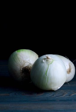 ahşap bir masa üzerinde üç soğan
