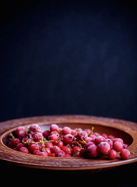 Gefrorene rote Johannisbeere in einem weißen Teller auf einem Tisch — Stockfoto
