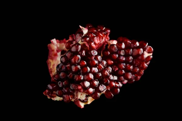 Juicy pomegranate on a black background — Stock Photo, Image