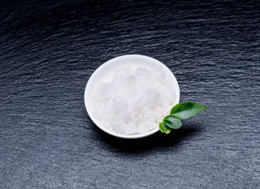 Kayrak bir yaban domuzu yapraklarda beyaz bir kase deniz kozmetik tuz